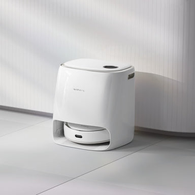 Narwal Freo Robot Vacuum and Mop in charging station on tile floor surface.